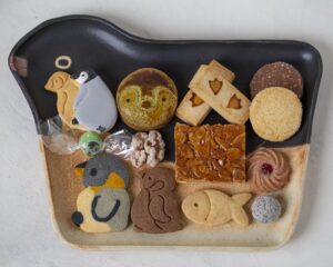 缶に入っている１３種類のクッキーや飴などのお菓子たち